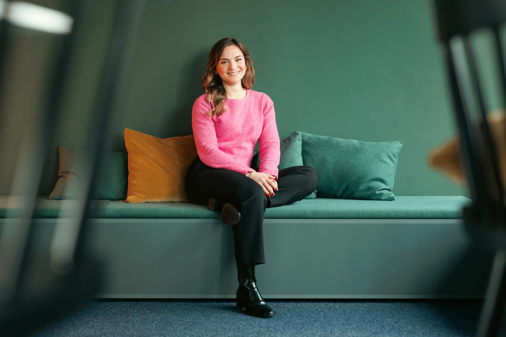 Ganzkörperporträt einer Kollegin in rosa Pullover